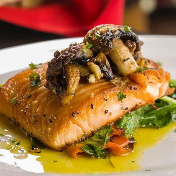 Pignetti's pan-seared salmon with roasted mushrooms, greens, and a lemon-butter sauce.