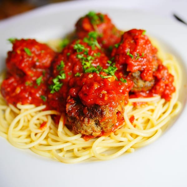 Pignetti's spaghetti and meatballs, topped with rich red sauce and fresh parsley.